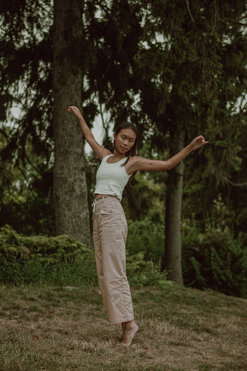 Ethnic woman balancing on tiptoes with hand apart