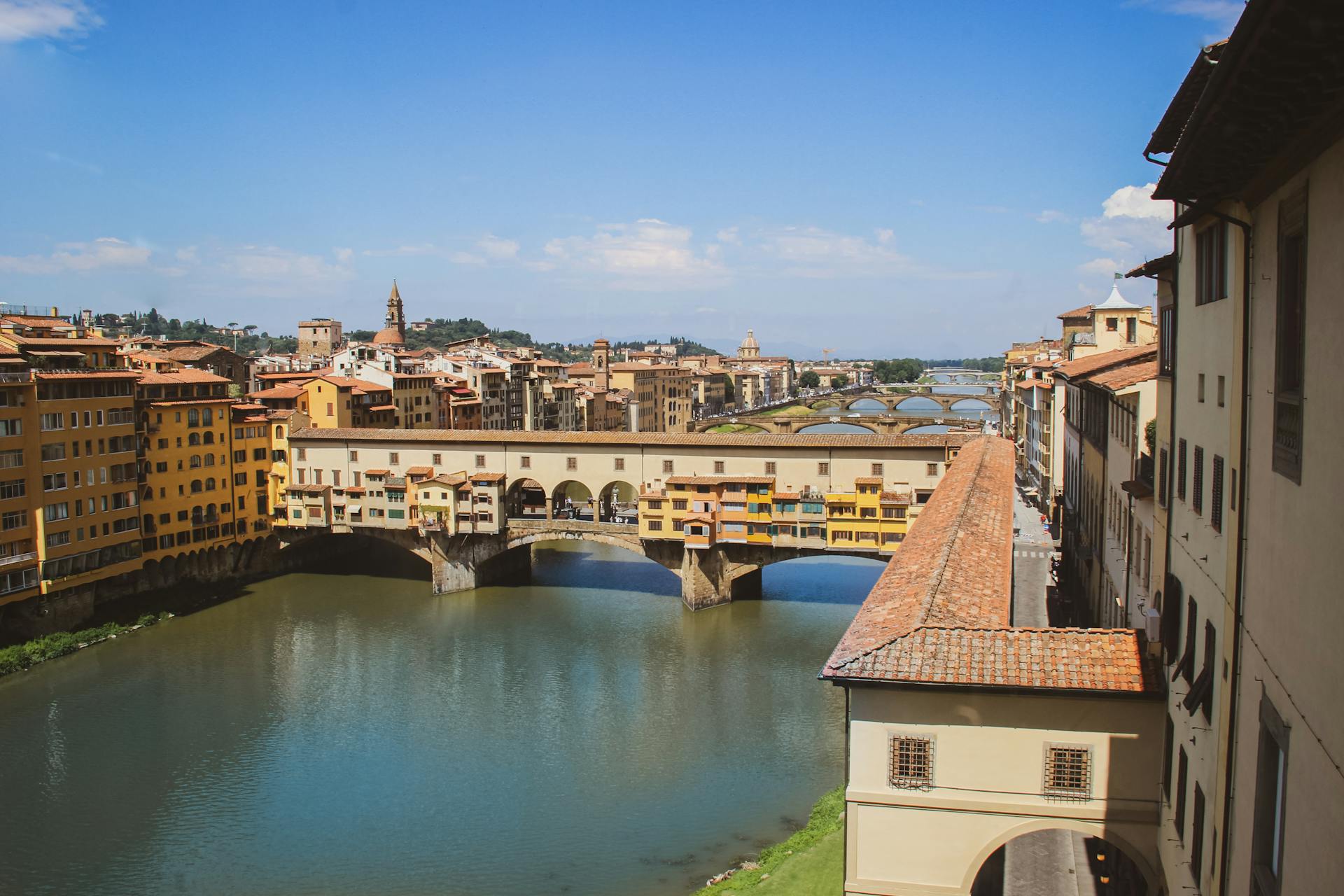 Stunning view of the historic Ponte Vecchio bridge in Florence, Italy on a bright day.