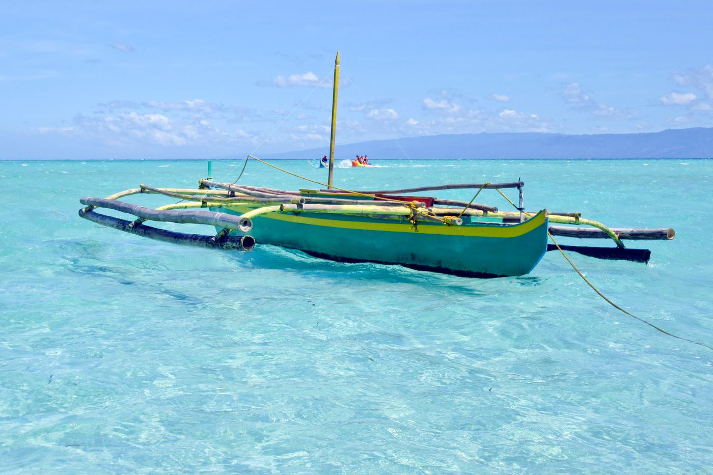 Outrigger boat on turquoise shallows, photo by Martin Hungerbühler on Pexels