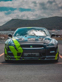 A sleek sports car parked on a mountain road with a cloudy sky background.