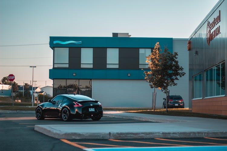 Shiny Coupe Car On Parking Lot In Sunlight