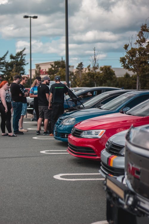 Free Group of people standing next to row of cars Stock Photo