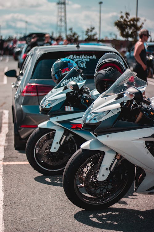 Motorcycles and cars on parking in daylight