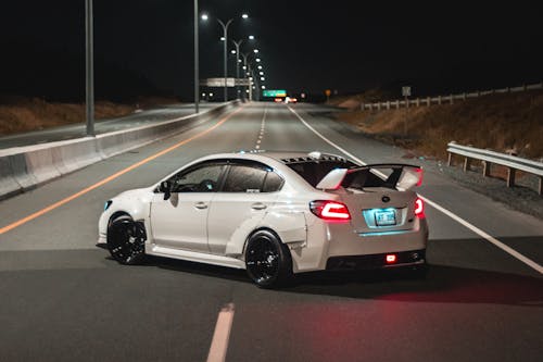 Sports car turning around on road at night