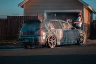 Faceless woman washing car with foam