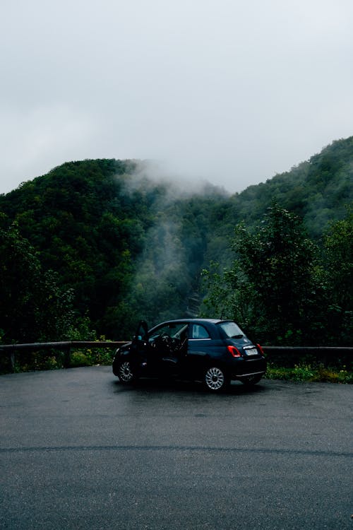 Car parked on roadside in verdant hilly nature