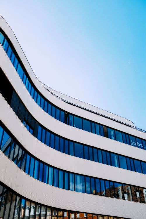 Free Creative facade of contemporary office building with curvy walls located in downtown under blue sky Stock Photo