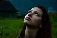 雨天里，一个女人抬头仰望的特写，引人沉思