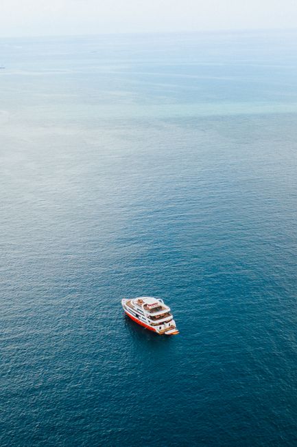 Aerial modern cruise ship sailing on endless rippling blue sea on clear day