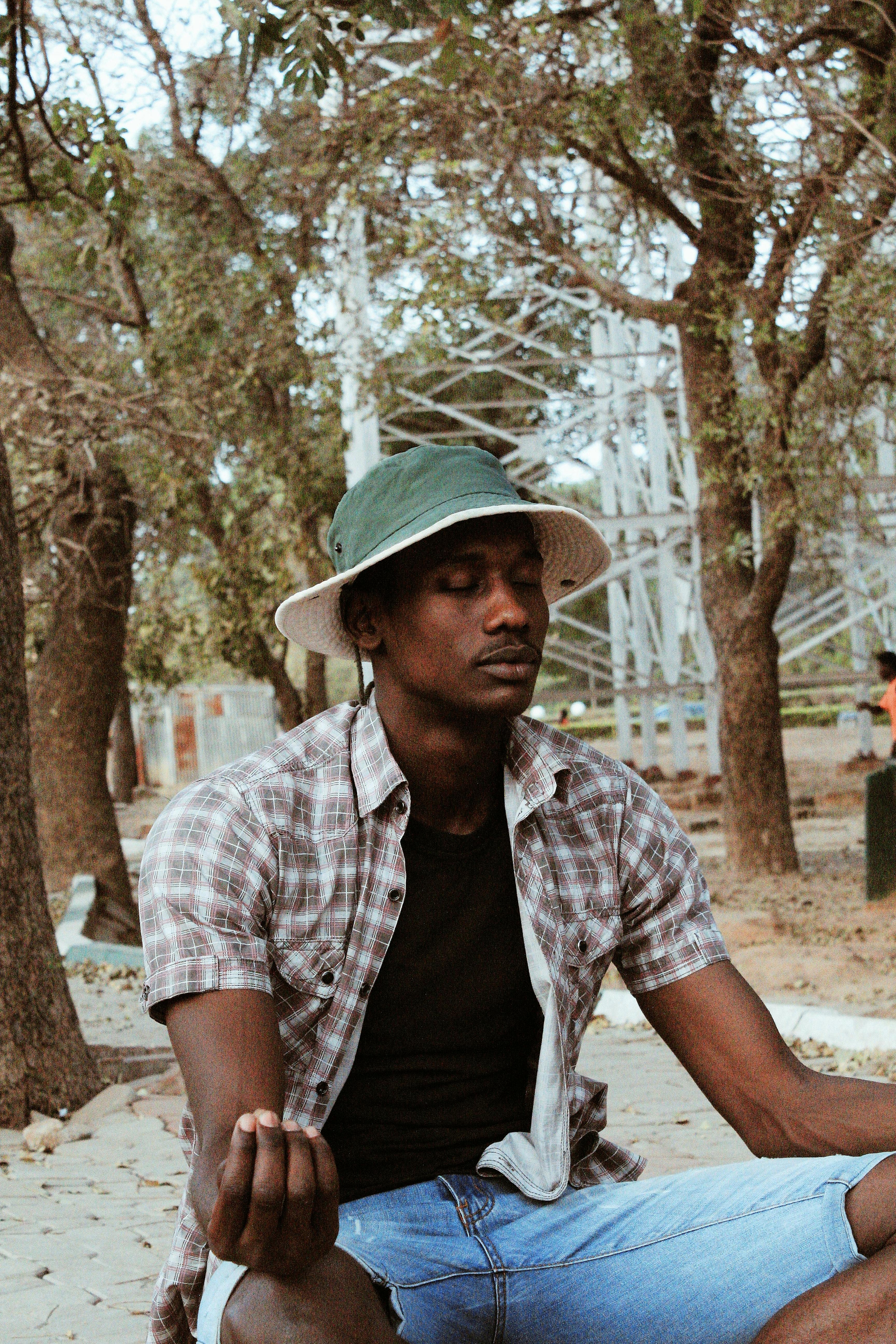 religious black man in trendy wear praying on street