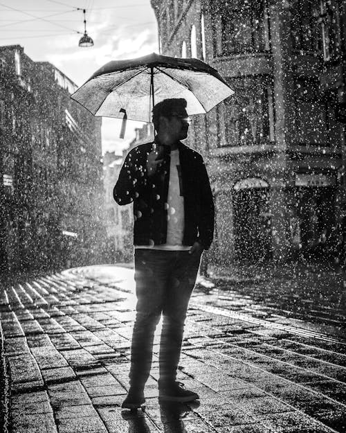 Free A Man Holding an Umbrella on a Rainy Day Stock Photo