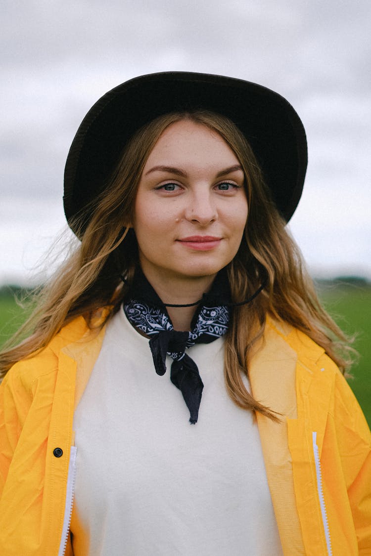 Woman In Hat And Bandana On Neck Standing In Nature