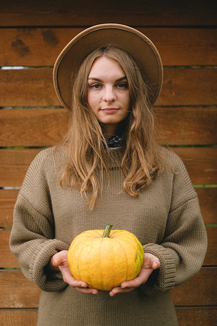 Calm Woman With Pumpkin In Countryside