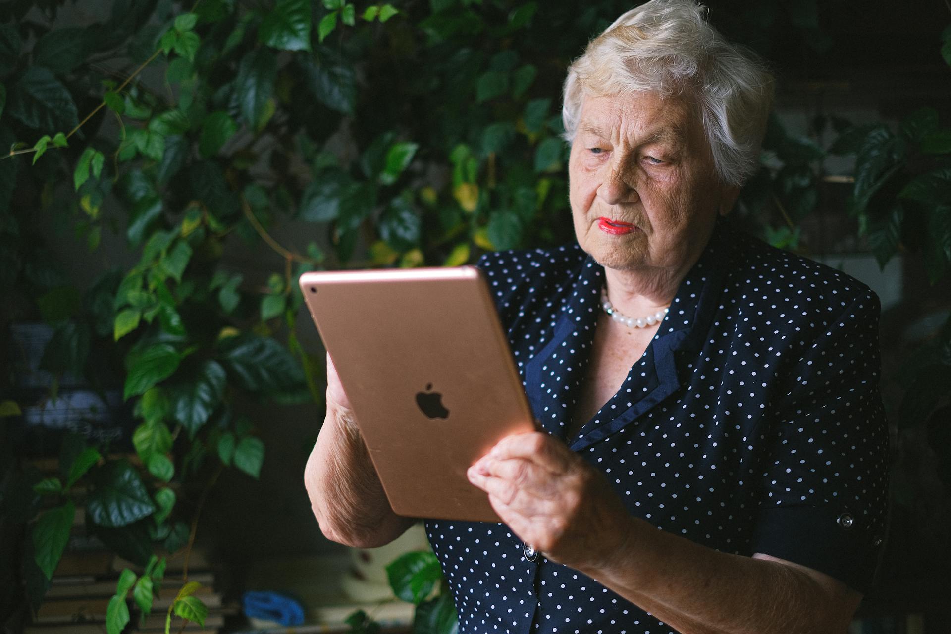 Oudere vrouw aan het scherm van een hedendaagse tablet