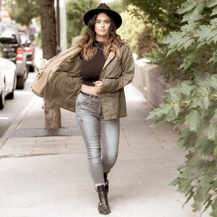 Woman In Trendy Hat And Parka Walking On Street