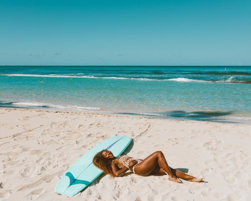 A Woman in Her Swimwear Lying Down on The Beach Sand