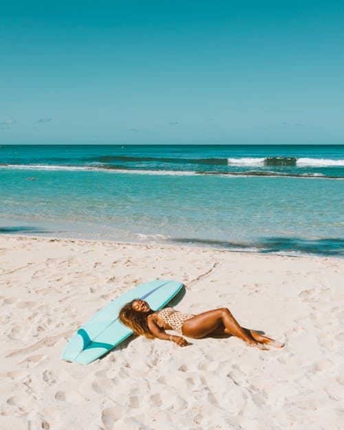 Free Woman Wearing Swimsuit Lying on Beach Sand Stock Photo