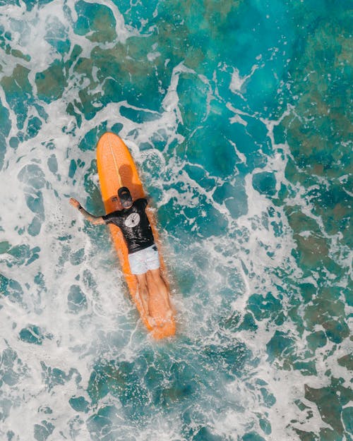 A Person in Prone Position in His Surfboard