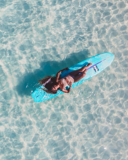 Free A Woman Lying on a Surfboard Stock Photo