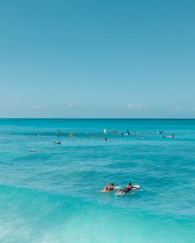 在晴朗的天空下，冲浪者享受着蓝色海浪的活力景色
