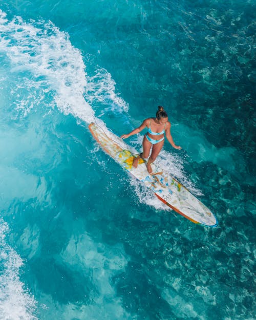 Free Woman in Bikini Surfing on the Sea Stock Photo