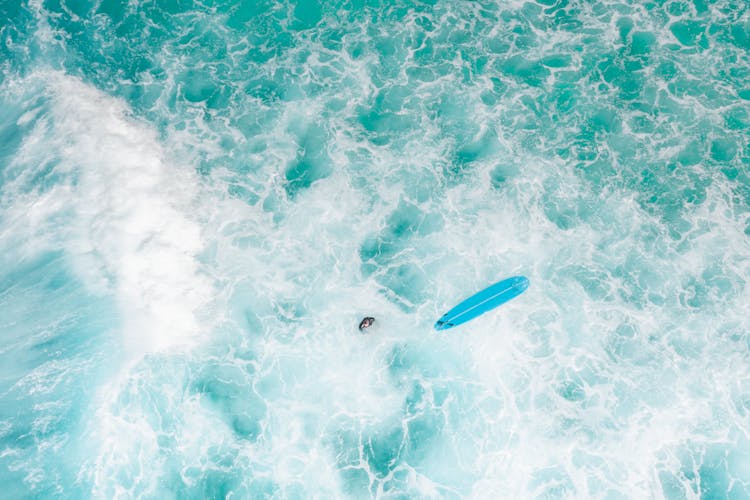 Surfer With Board Surfing On Ocean Waves