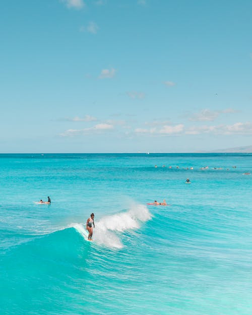 People Surfing on Sea