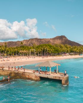 Explore this stunning tropical beach with palm trees, a pier, and picturesque mountains.