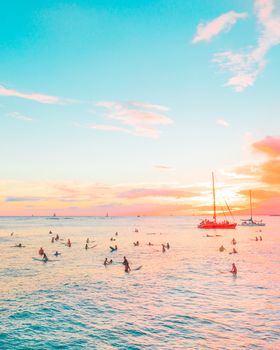 一群冲浪者在海上冲浪，背景是令人惊叹的夏日日落