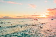 People Swimming in Ocean on Sunset