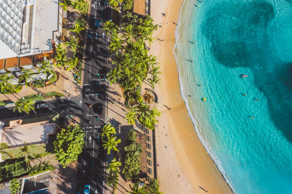West Maui and Molokai Special 45-Minute Helicopter Tour - An aerial shot of a sandy beach with turquoise waters and palm trees lining a resort.