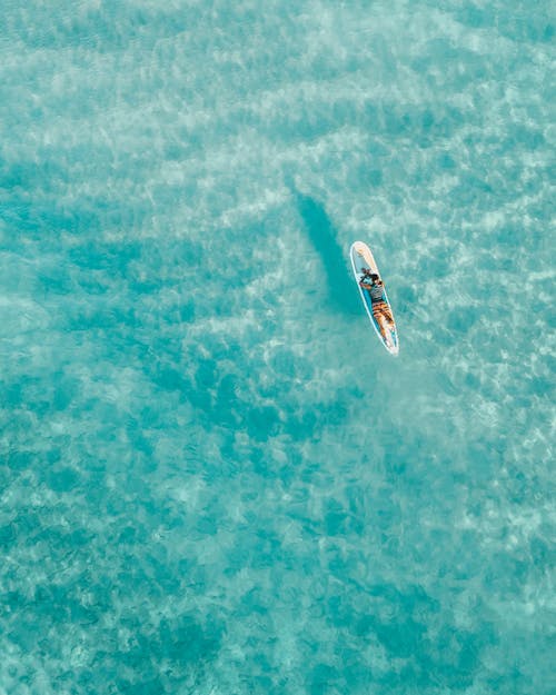Person on Surfboard on Blue Sea