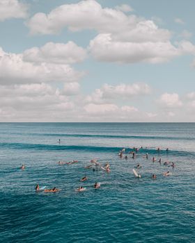 在明亮的夏日天空下，冲浪者享受着蔚蓝的海洋