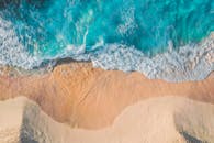 碧绿色的海浪拍打沙滩的令人惊叹的鸟瞰图，非常适合自然爱好者