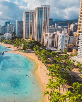 Stunning aerial view of Waikiki Beach with vibrant ocean and Honolulu skyscrapers.