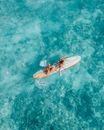 Woman in Red Bikini Top Riding on White and Blue Surfboard on Body of Water during