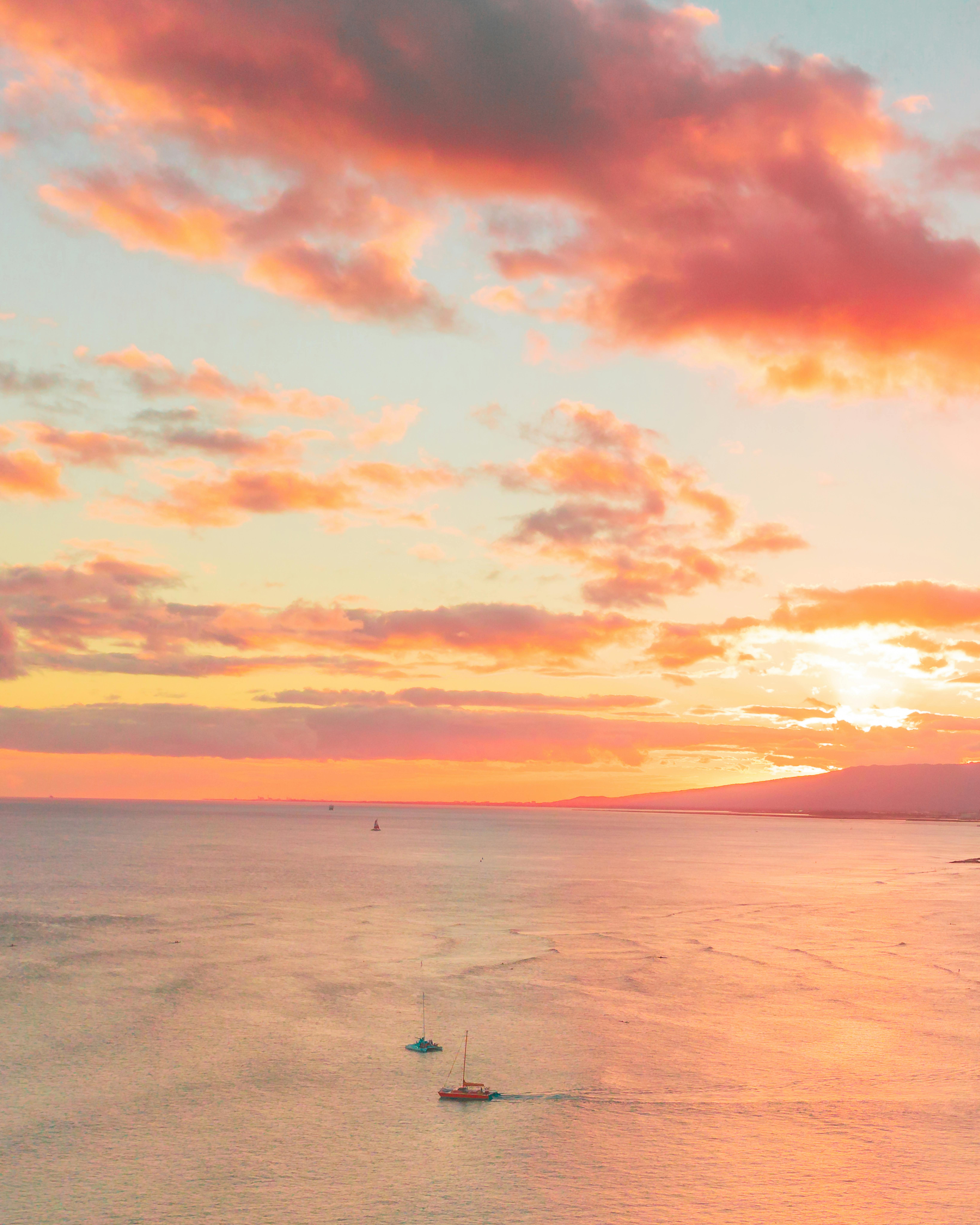 大海上，帆船与令人惊叹的日落，呈现出宁静而充满活力的景象