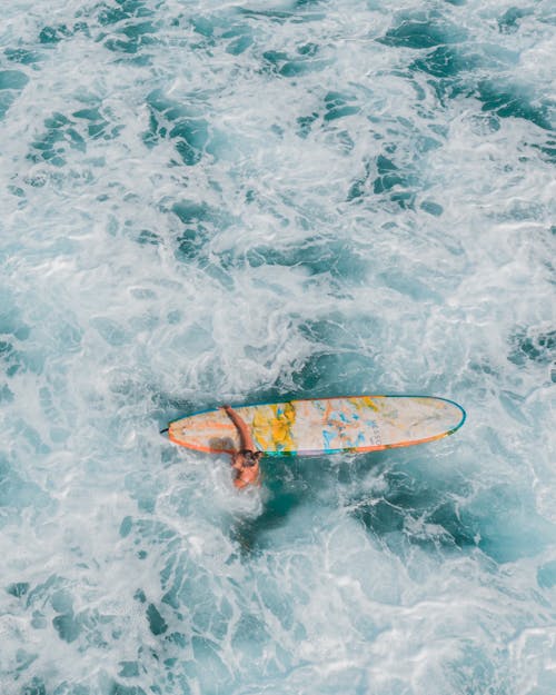 Woman with Surfboard Swimming Through Water
