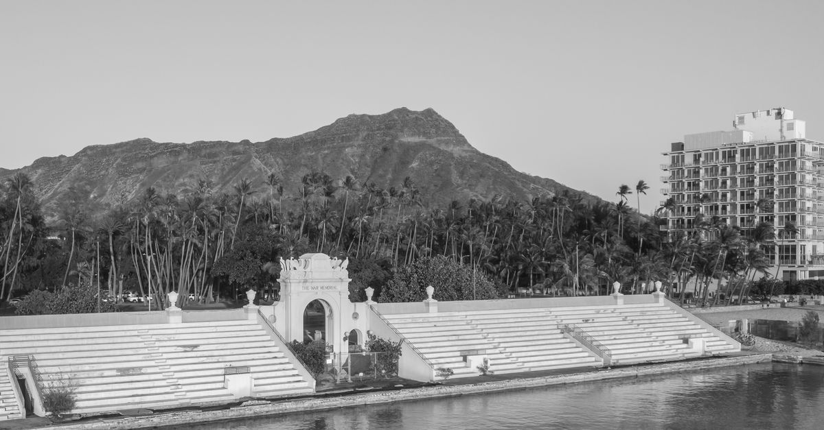 Photo by Jess Loiterton A captivating black and white photograph of Diamond Head with the War Memorial Natatorium.
