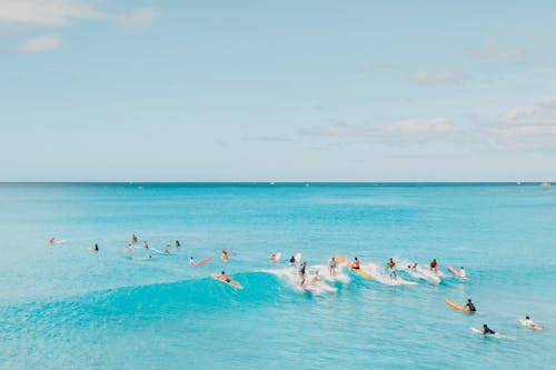 Free People Surfing on a Blue Sea Stock Photo