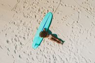 Top View of Of Woman Lying Down on a Sandy Beach with a Surfboard