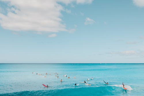 People Surfing on a Blue Sea