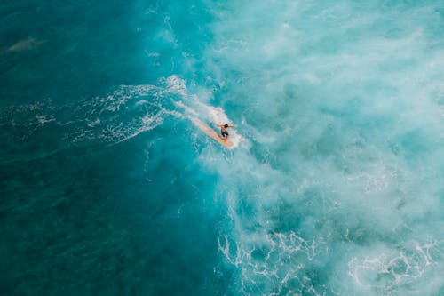 Man Surfing on Beautiful Blue Sea Water