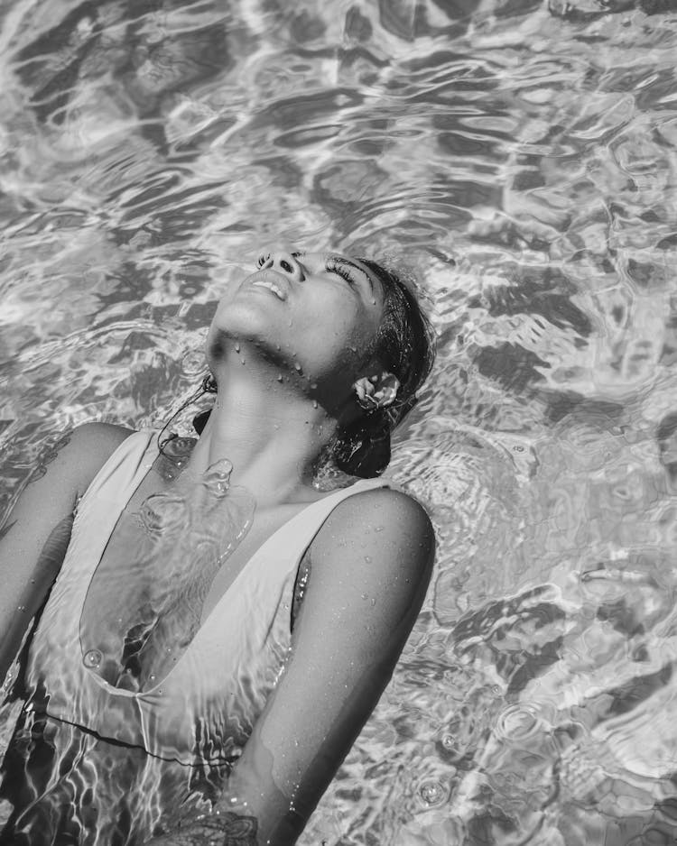 Woman Floating On A Water Surface On Her Back 