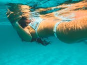 一名女子身着比基尼，在清澈的海水中游泳
