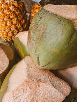 A vibrant close-up of freshly cut coconuts and a ripe pineapple, showcasing tropical freshness.