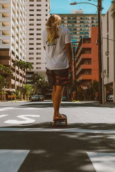 一名年轻滑板者穿着白衬衫，在充满活力的城市街道上骑行