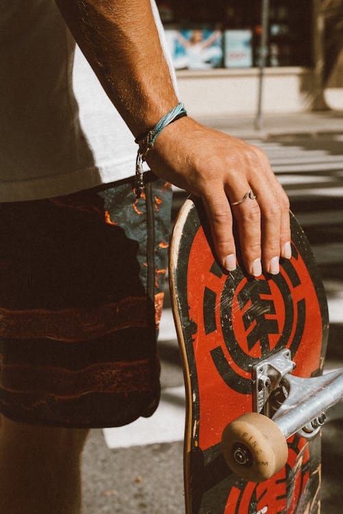 Person Holding Red and Black Skateboard