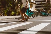 Man in White Shirt and Brown Shorts Riding Blue Bicycle on Road