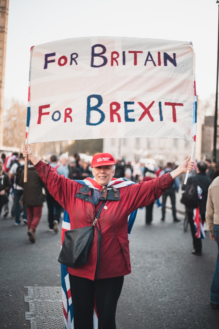 A Woman In Red Jacket Holding A Banner